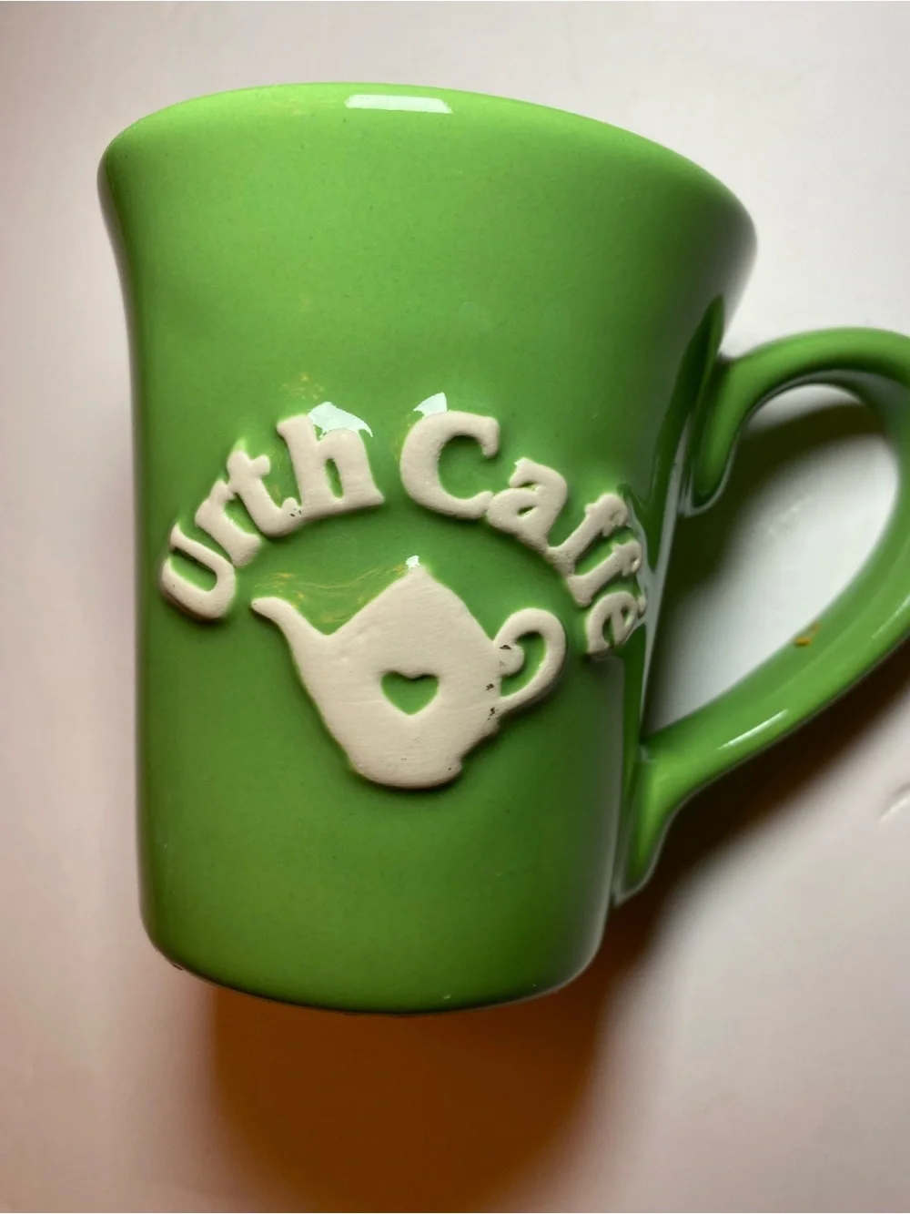 Urth Cafe ceramic coffee mug in green with white embossed logo